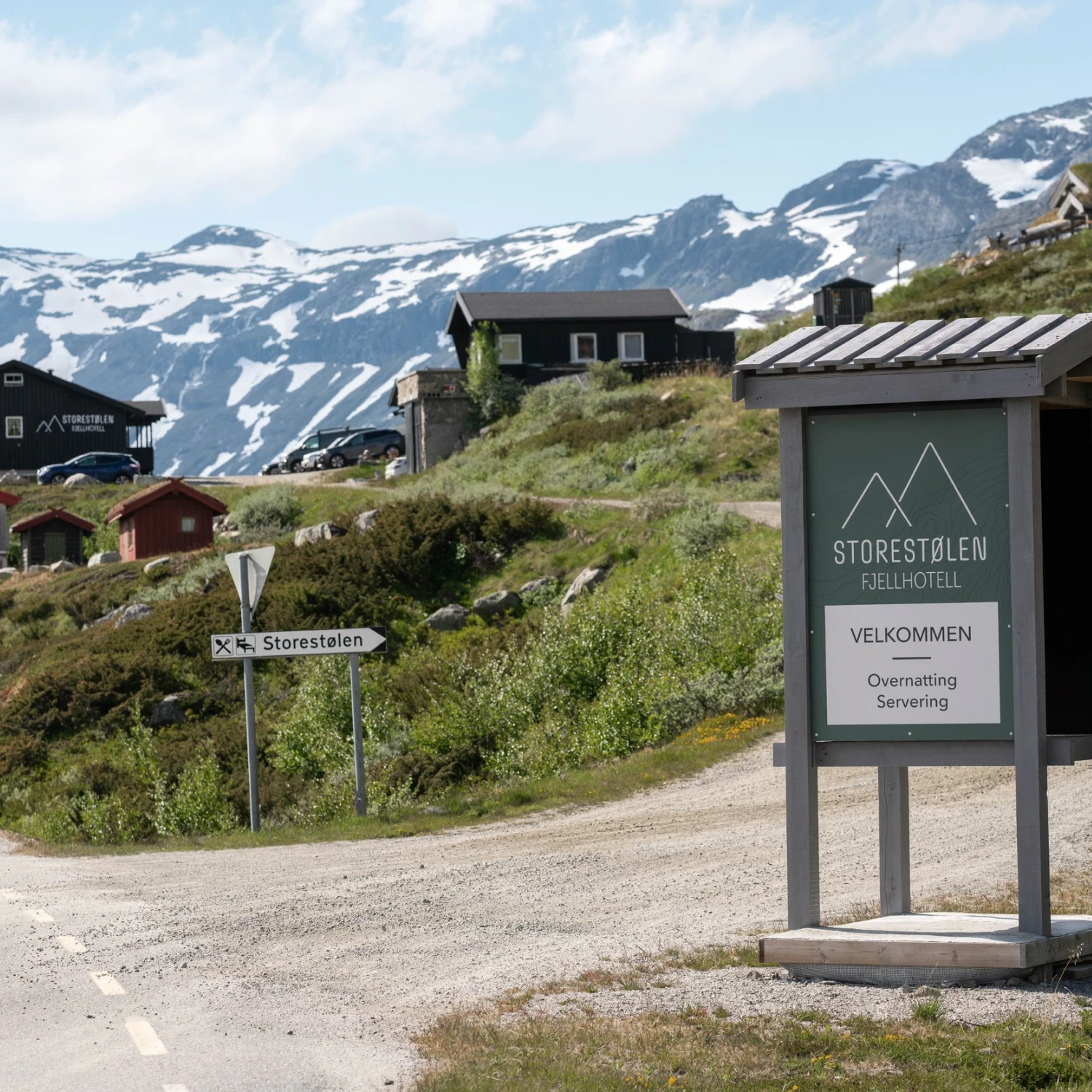 Skilt ved innkjørselen med hotellet i bakgrunnen